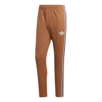 بنطال رياضي رجالي من adidas originals مخطط بشعار كلاسيكي مطبوع عليه شعار الشركة المصنعة، لون بني، IB3430